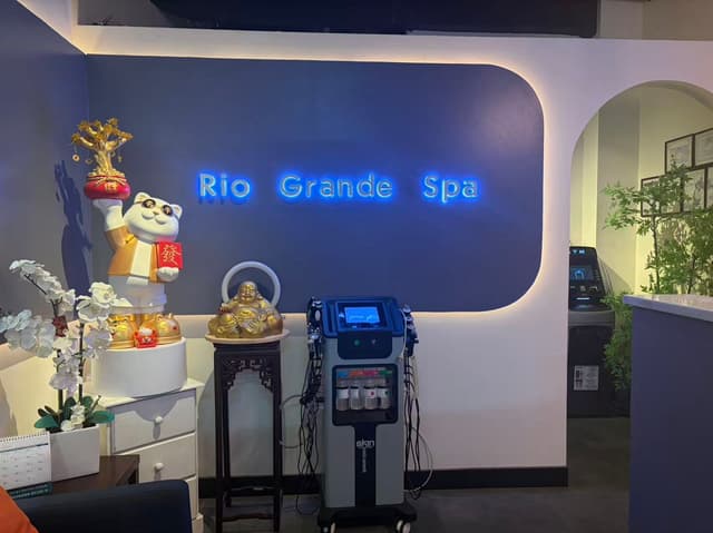 HydroFacial skincare equipment and lucky cat display beneath blue neon signage at a Lower Manhattan spa